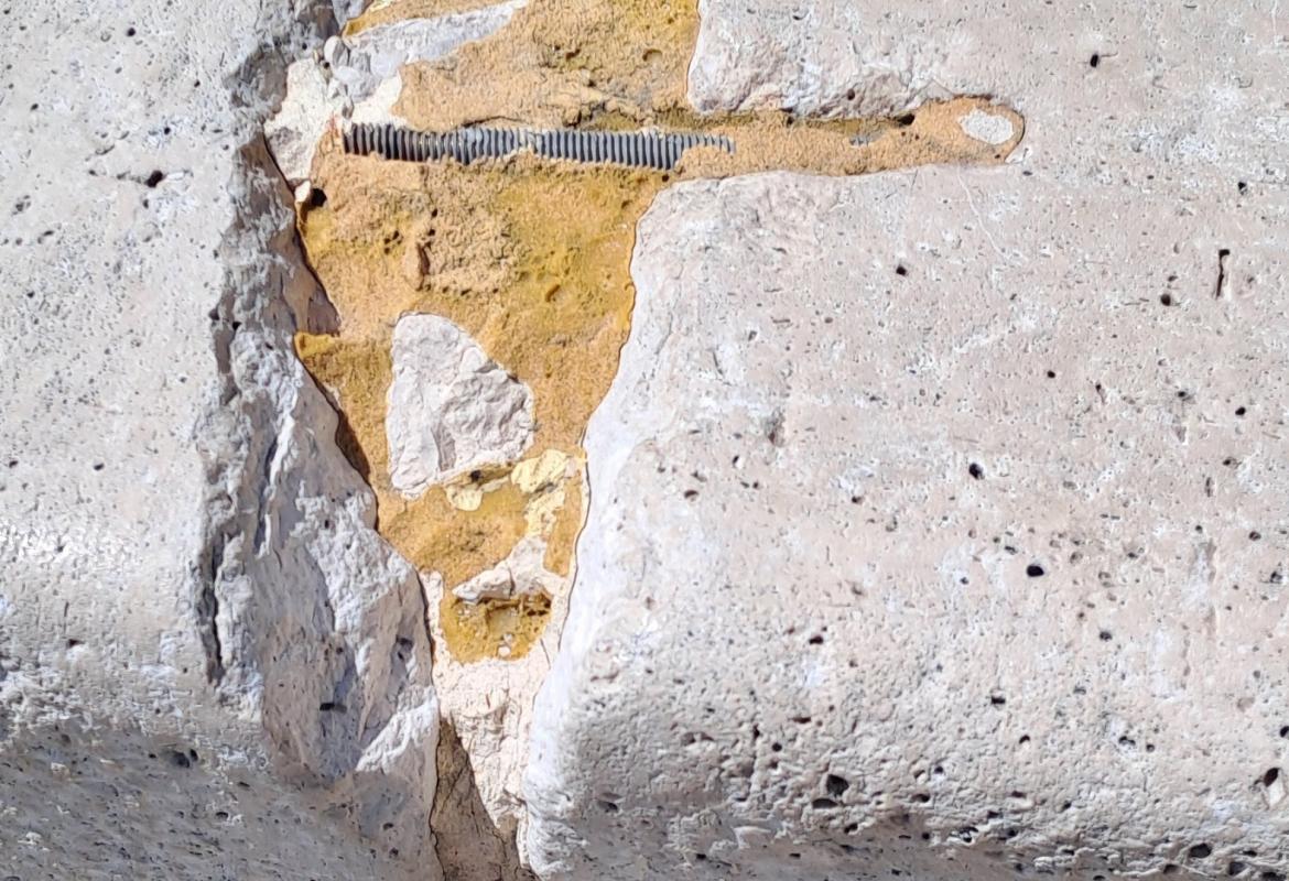 grapa incrustrada en la piedra en mal estado de conservación