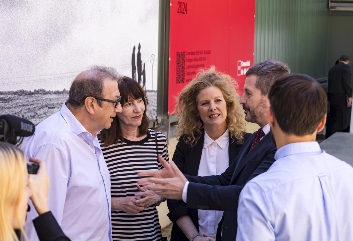 El consejero de Cultura de la Comunidad de Madrid y la comisaria de la exposición hablando con el fotógrafo Javier Campano en la inaguración