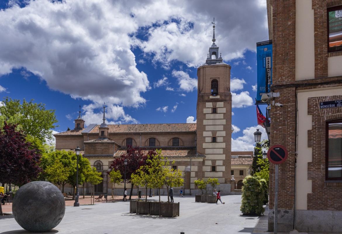 Plaza con iglesia con fachadas de ladrillo y torre cuadrangular