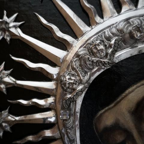 imagen en detalle de una pintura en la que se observa una mujer con corona plateada 