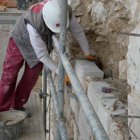 Obras de intervención en el castillo de Torremocha operario de restauración interviniendo en la muralla