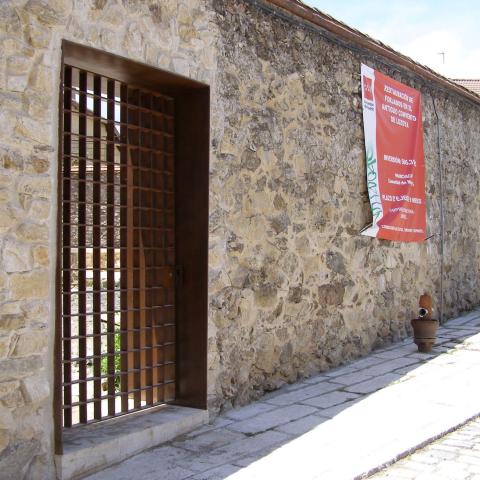 Estado reformado. Nueva puerta del muro norte tras la intervención Imagen de una fachada de piedra con puerta de acceso y reja