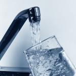 Grifo de una casa llenando un vaso de agua